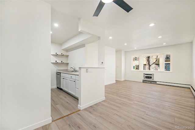 kitchen featuring sink, light hardwood / wood-style flooring, ceiling fan, white cabinets, and stainless steel dishwasher