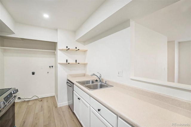 kitchen featuring stainless steel appliances, light hardwood / wood-style floors, sink, and white cabinets