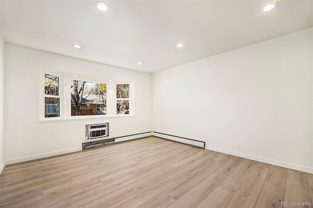 unfurnished room with a wall mounted AC and light hardwood / wood-style flooring