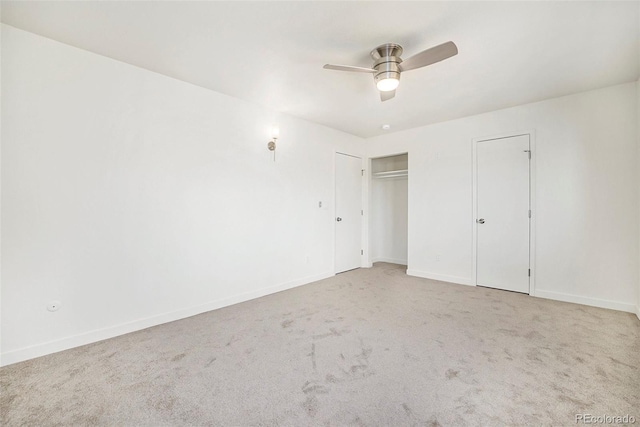 unfurnished bedroom featuring carpet floors, two closets, and ceiling fan