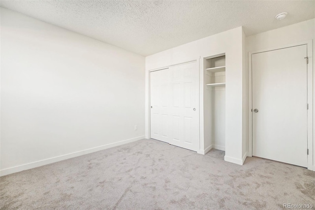 unfurnished bedroom with light colored carpet and a textured ceiling