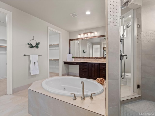 bathroom featuring plus walk in shower, tile patterned flooring, and vanity