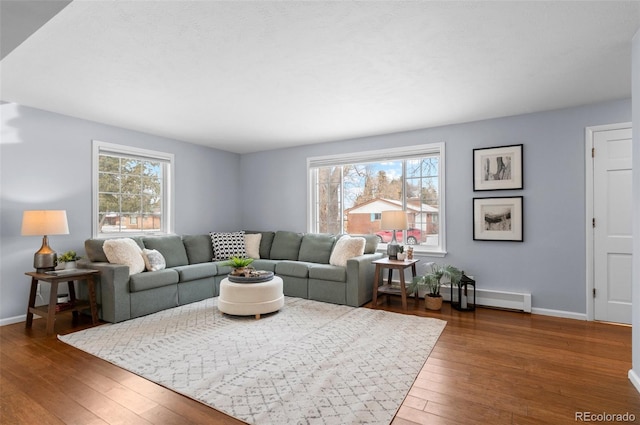 living room featuring a baseboard heating unit and dark hardwood / wood-style floors