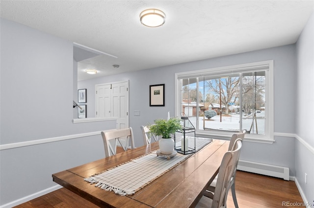 dining space with a baseboard radiator and wood-type flooring