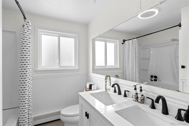 full bathroom with vanity, toilet, a baseboard heating unit, and shower / bath combo