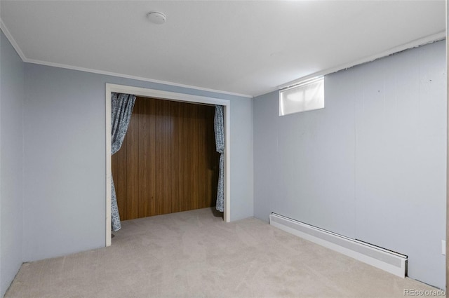 interior space featuring baseboard heating, light colored carpet, a closet, and crown molding