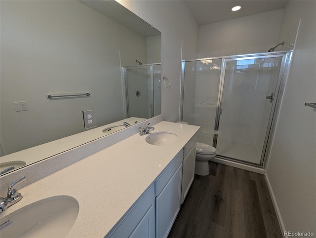 bathroom featuring hardwood / wood-style floors, vanity, toilet, and an enclosed shower