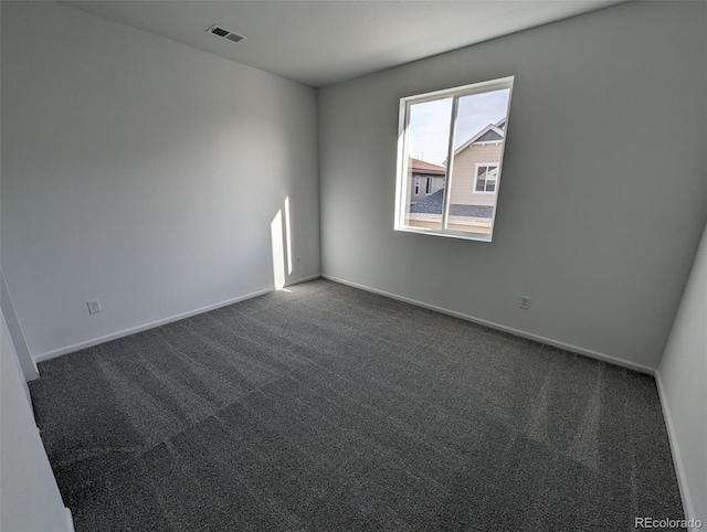 spare room featuring dark carpet