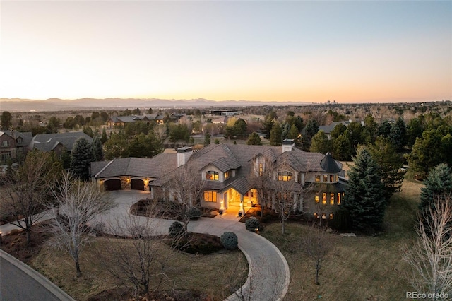 view of front of house featuring curved driveway and a mountain view