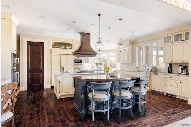kitchen featuring cream cabinetry, premium range hood, and a center island