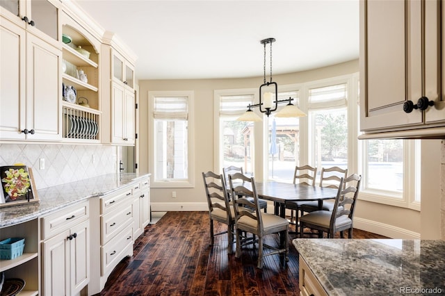 dining space with baseboards and dark wood-type flooring