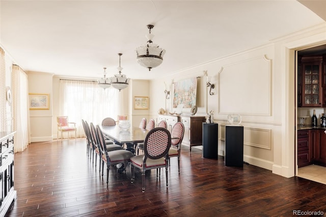 dining area featuring baseboards, ornamental molding, dark wood finished floors, and an inviting chandelier