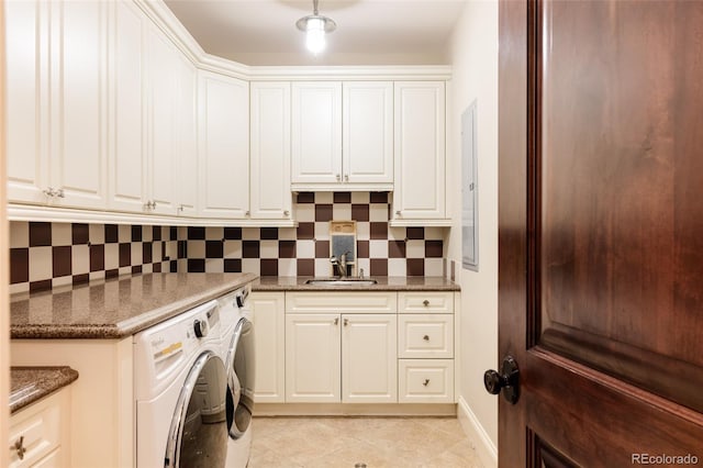 laundry area with a sink, cabinet space, light tile patterned flooring, washer and dryer, and baseboards