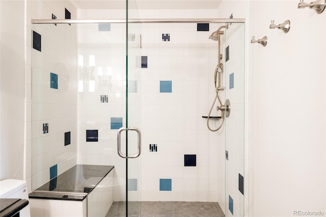 bathroom featuring toilet and a shower stall