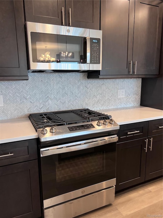 kitchen with backsplash, dark brown cabinets, and stainless steel appliances