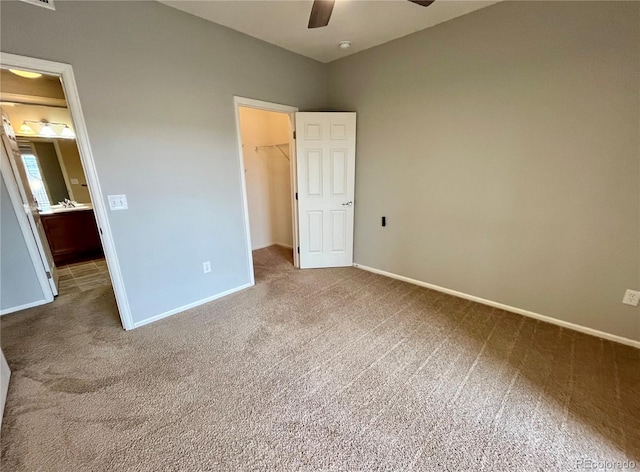 unfurnished bedroom with ceiling fan, a walk in closet, a closet, and carpet