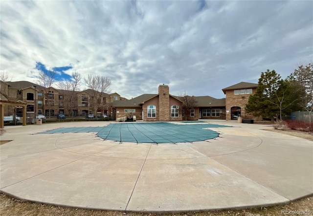 view of pool with exterior fireplace and a patio area