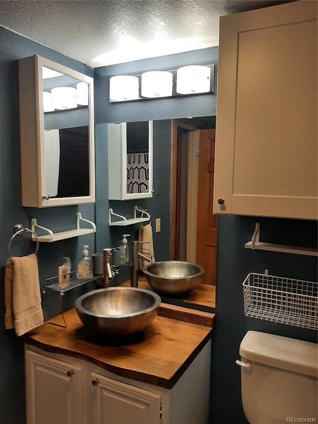 1525 Shadow Run Frontage Unit 204, Steamboat Springs, CO 80487 - half bath featuring a textured ceiling, vanity, and toilet