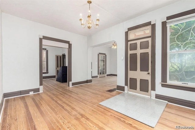 entrance foyer featuring light wood-style floors, baseboards, and ceiling fan with notable chandelier