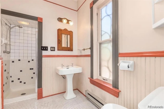 full bath with toilet, wainscoting, baseboard heating, and a stall shower