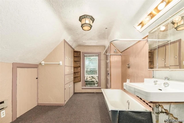 bathroom featuring carpet floors, a textured ceiling, a bath, and vaulted ceiling