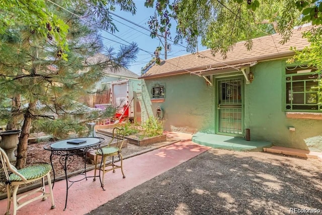rear view of property with fence, a patio, stucco siding, and a shingled roof