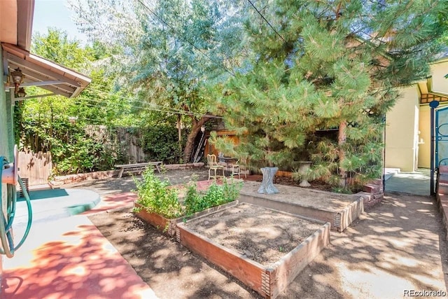 view of yard with a fenced backyard, a garden, and a patio area
