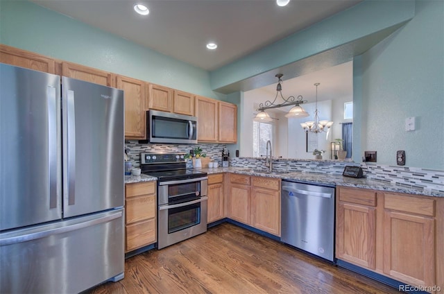 kitchen with light brown cabinets, a sink, dark wood-style floors, appliances with stainless steel finishes, and decorative backsplash