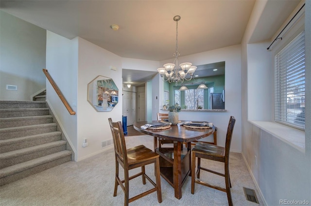 dining room with stairs, a notable chandelier, carpet flooring, and visible vents