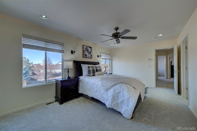 bedroom featuring baseboards, multiple windows, and light colored carpet