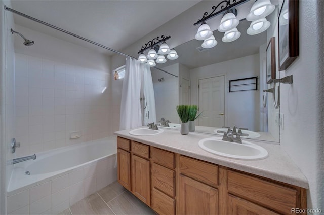 bathroom with a sink, tiled shower / bath combo, and double vanity