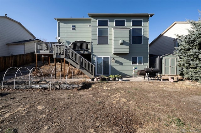 rear view of property featuring a shed, stairway, a wooden deck, an outdoor structure, and heating fuel