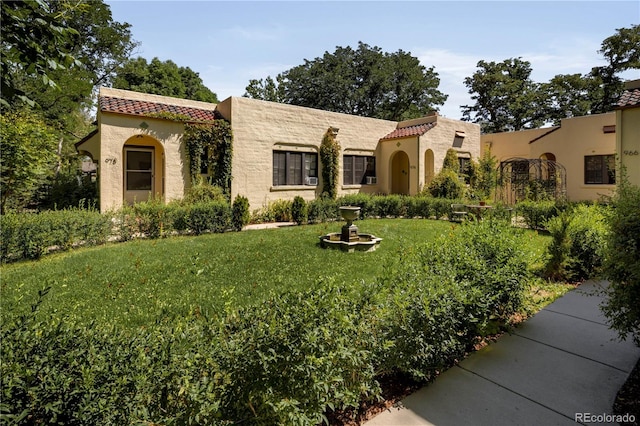 mediterranean / spanish-style house featuring a front lawn