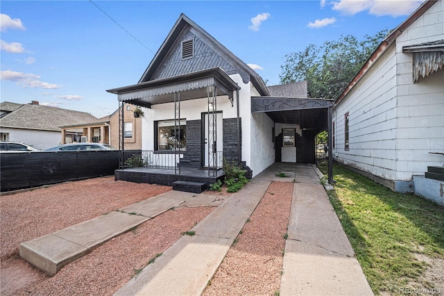 1209 E Routt Ave, Pueblo, CO 81004 - view of front of home featuring driveway, a carport, stucco siding, and a porch