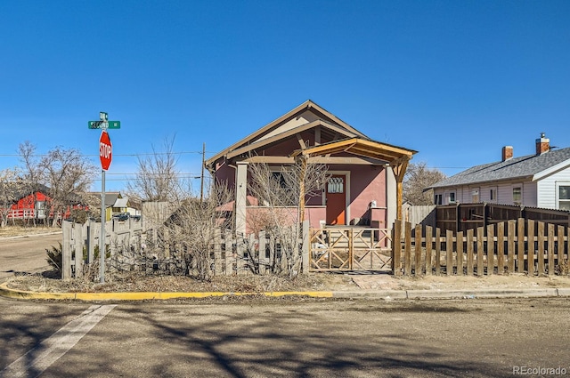 shotgun-style home featuring fence