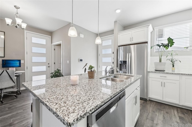 kitchen with sink, appliances with stainless steel finishes, white cabinetry, hanging light fixtures, and a center island with sink