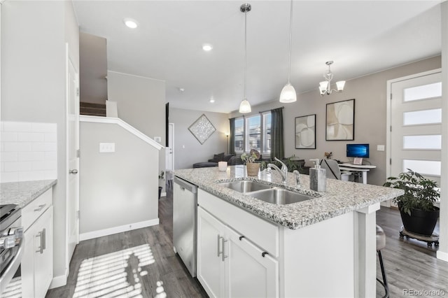 kitchen with sink, decorative light fixtures, a center island with sink, appliances with stainless steel finishes, and white cabinets