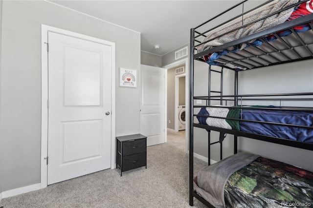 bedroom featuring washer / dryer and carpet flooring