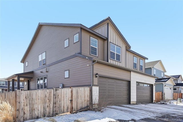 snow covered property with a garage