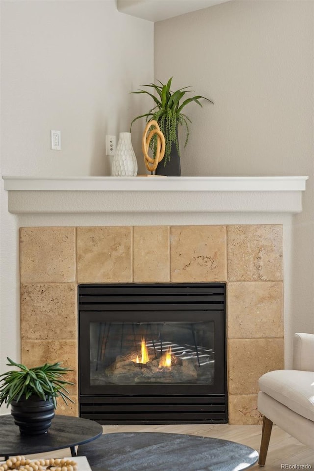 interior details with wood finished floors and a tile fireplace
