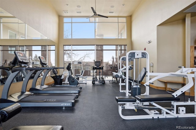 exercise room with visible vents and a high ceiling