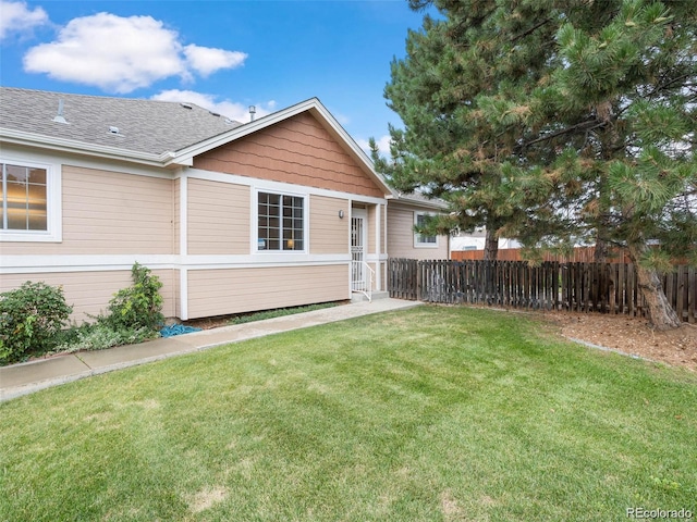 rear view of property featuring a lawn