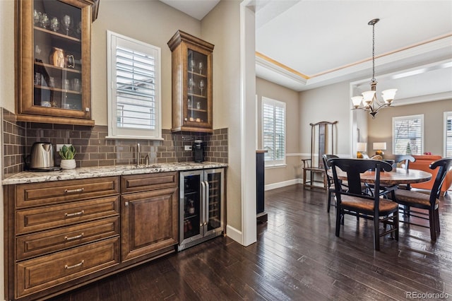 4937 Hogback Ridge Rd, Morrison, CO 80465 - bar with a sink, decorative backsplash, beverage cooler, an inviting chandelier, and dark wood-style floors