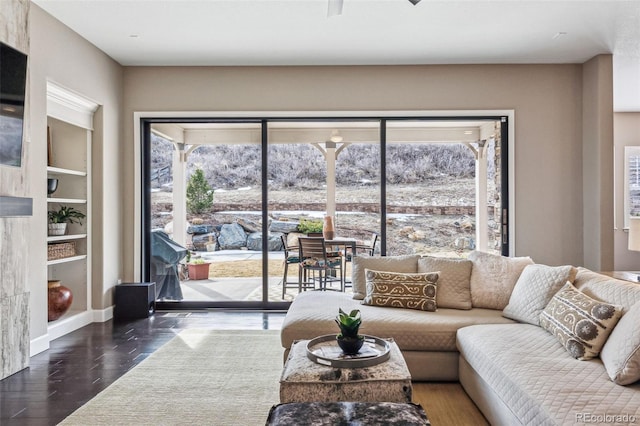 4937 Hogback Ridge Rd, Morrison, CO 80465 - living area featuring built in shelves, ceiling fan, a wealth of natural light, and wood finished floors