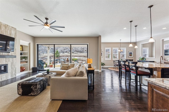 4937 Hogback Ridge Rd, Morrison, CO 80465 - living area featuring built in shelves, ceiling fan, a premium fireplace, baseboards, and recessed lighting