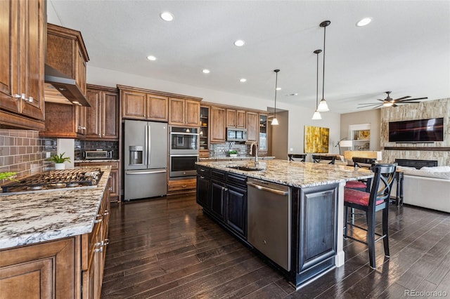 4937 Hogback Ridge Rd, Morrison, CO 80465 - kitchen featuring a sink, open floor plan, a breakfast bar, appliances with stainless steel finishes, and dark wood-type flooring