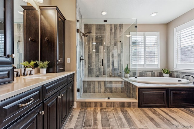 4937 Hogback Ridge Rd, Morrison, CO 80465 - bathroom featuring a garden tub, vanity, wood finished floors, and a stall shower