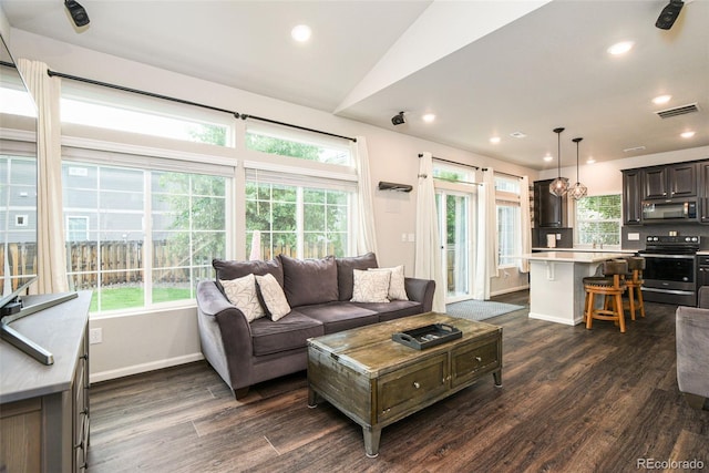 213 S Old Hammer Ct, Aurora, CO 80018 - living room featuring healthy amount of natural light, dark wood-style floors, recessed lighting, and vaulted ceiling