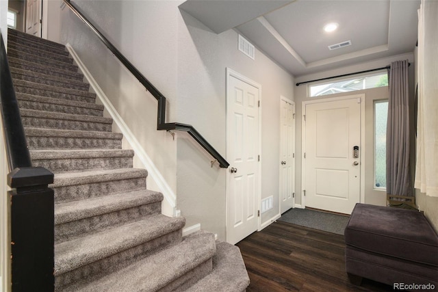 213 S Old Hammer Ct, Aurora, CO 80018 - entryway featuring stairway, dark wood-style flooring, and a raised ceiling