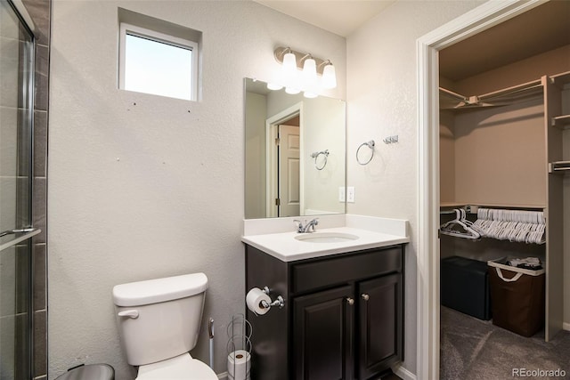 213 S Old Hammer Ct, Aurora, CO 80018 - full bathroom featuring a walk in closet, vanity, and a shower with door